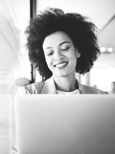 Black-and-white photo of a person using a laptop.