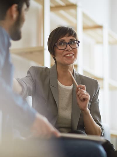 Two people sit in an office in discussion.