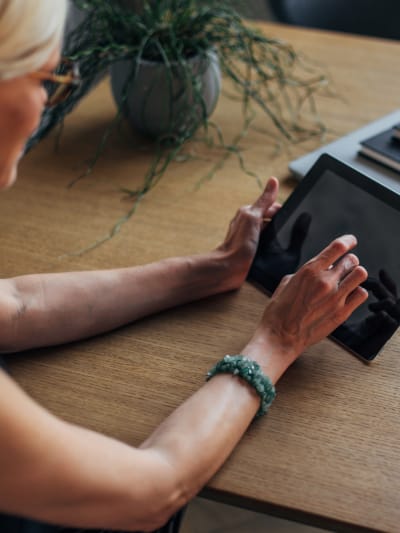 Person at a desk uses a tablet computer.