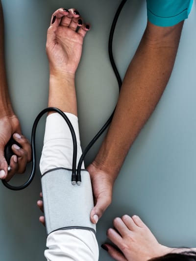 Healthcare professional takes blood pressure of a patient.