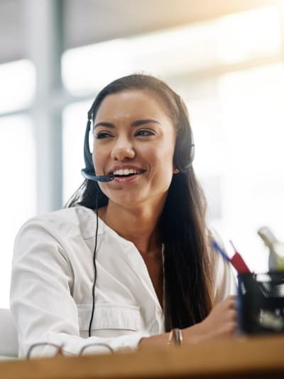 Medical professional sits at a desk, talking on a headset.