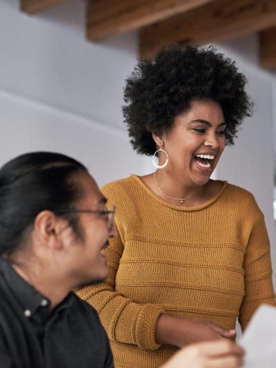 Happy employees laugh together in an office.