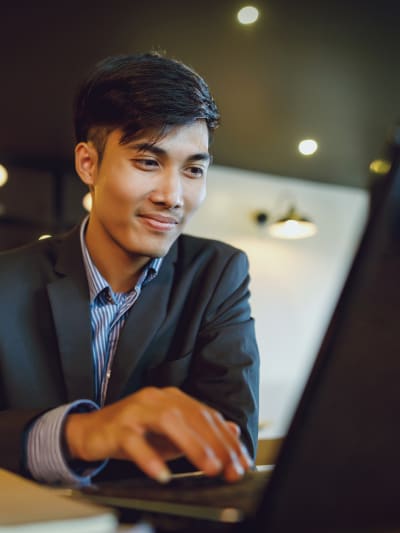 Man smiling and working on laptop