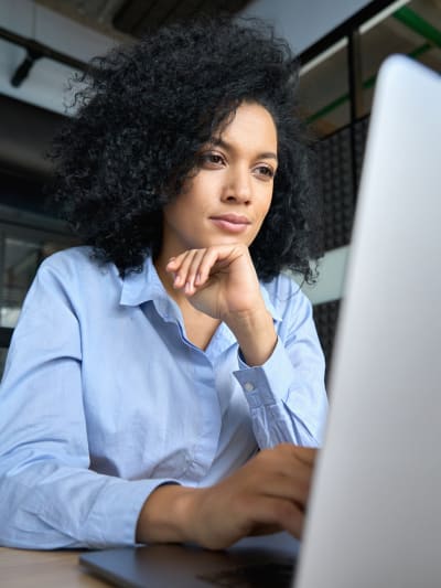 A media professional manages content efficiently on their laptop as they work in an office space.