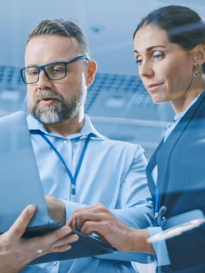 Stylish confident businesswoman and businessman working on a project in a modern and bright facility