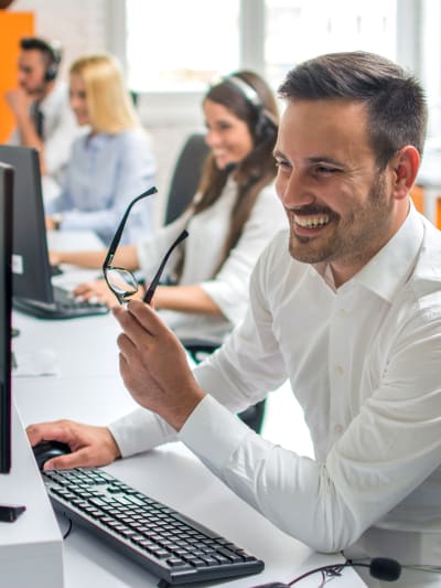 Man smiling while working on computer in office