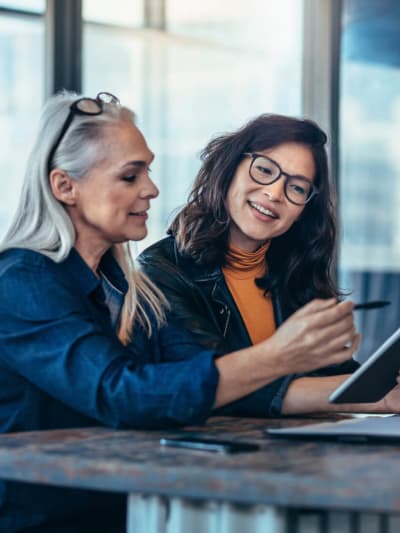 Two women sharing ideas on tablet