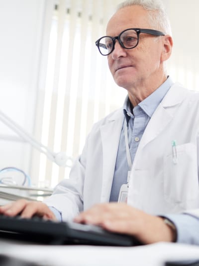 Doctor working on computer with medical records