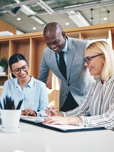 A group of young professionals talking and smiling on a table.