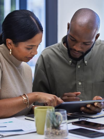 Two office coworkers looking at a tablet