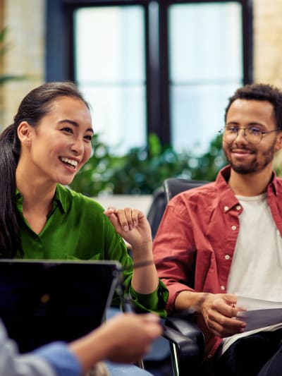 Four smiling office coworkers talking