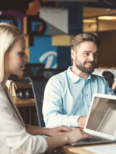 Office coworkers looking at tablets and laptops