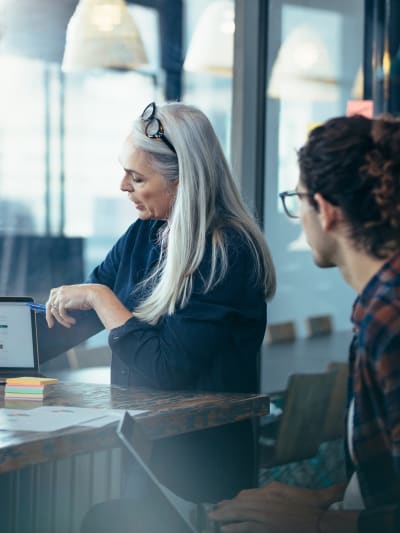 woman and man in office looking at laptop