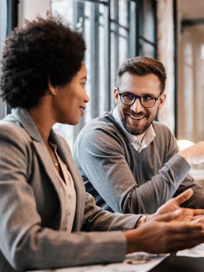 smiling man and woman in office discuss work