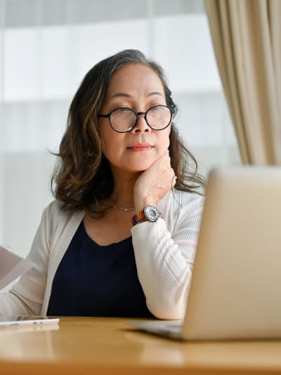 Business professional sits at a desk with a laptop computer.