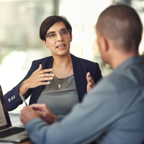 Three co-workers in a modern office setting discuss analyst coverage of Hyland.