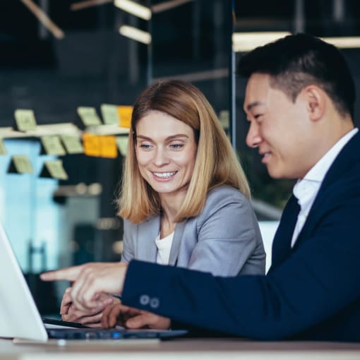 A young man and woman discussing over a work laptop.