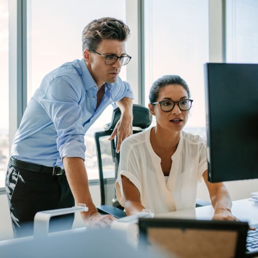 Two people looking at a monitor screen