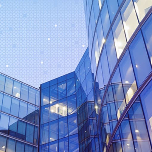 Multistory glass and steel building against a blue sky.