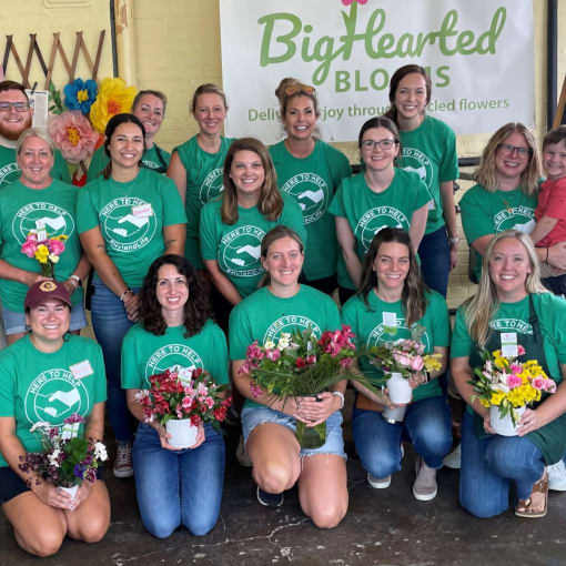 Hyland employees pose with their volunteer flower arrangements at BigHearted Blooms.