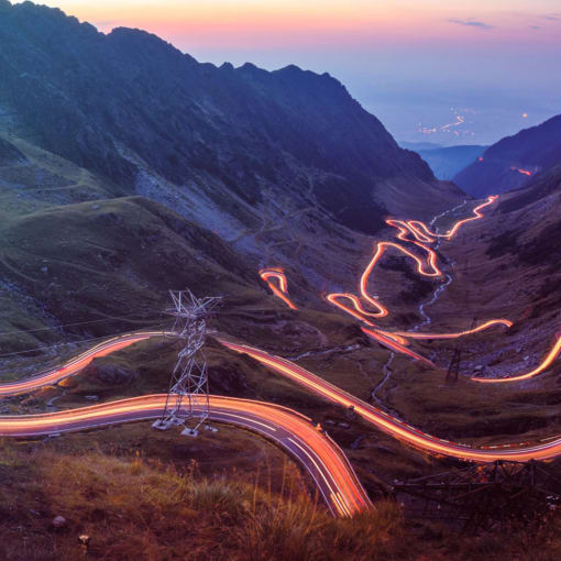 Long exposure of vehicles winding on hilly roads.