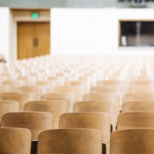 Empty auditorium with wooden seats.