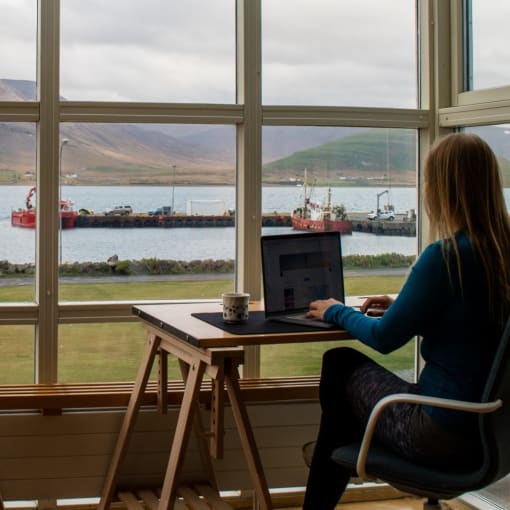 Person works from home overlooking hills and a lake.