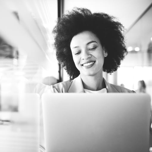 Black-and-white photo of a person using a laptop.