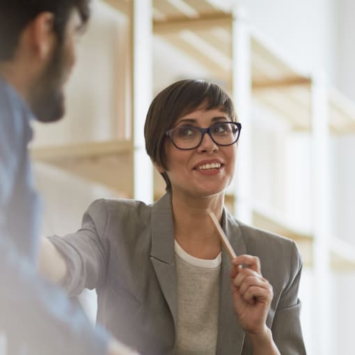 Two people sit in an office in discussion.