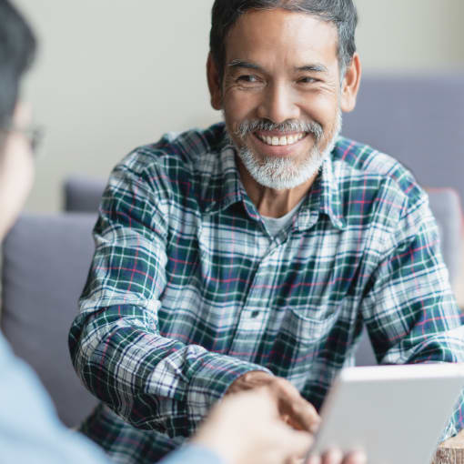 Two people discuss medical results shown on a tablet computer.