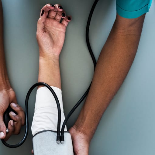 Healthcare professional takes blood pressure of a patient.