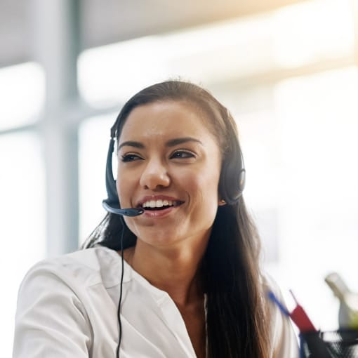 Medical professional sits at a desk, talking on a headset.