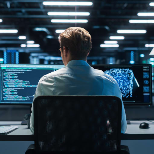 Computer analyst sits in a modern data center.