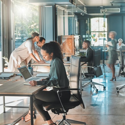 Young professionals work in an open office setting.