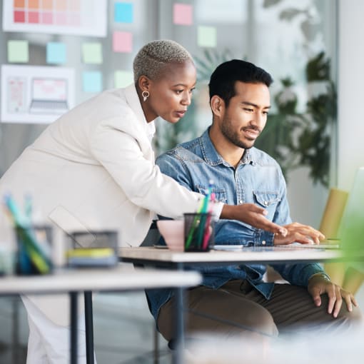 Business people discussing work on laptop in an office setting