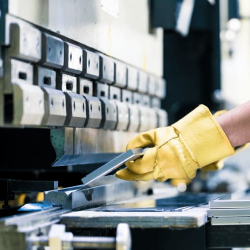 Yellow gloved hands with machinery 