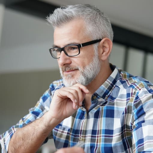 Person in glasses at laptop.