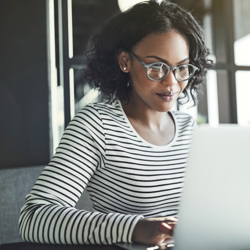 A person sits at their laptop to learn more about how their organization could partner with Hyland. 