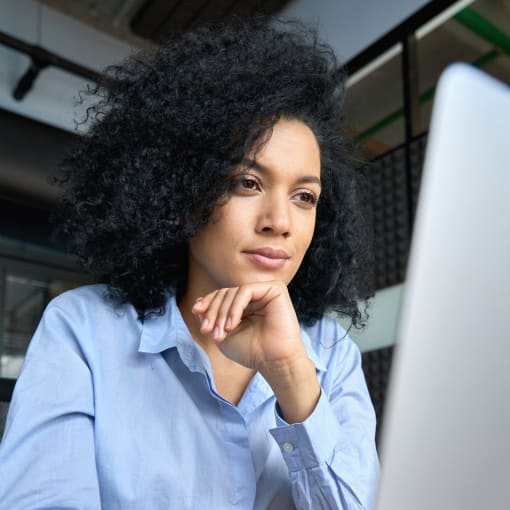 A media professional manages content efficiently on their laptop as they work in an office space.