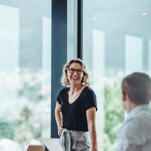 Two businesspeople evaluate vendors in a modern office space.