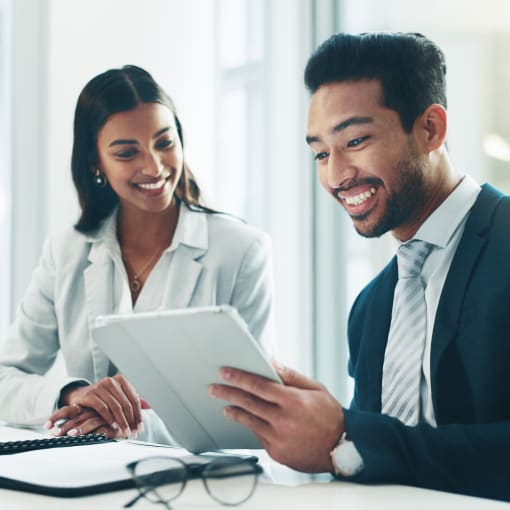 People smiling at tablet in meeting room