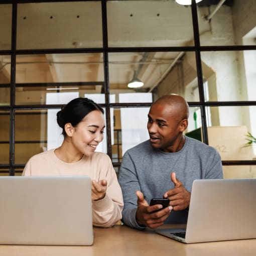 Woman and man having a discussion with laptops