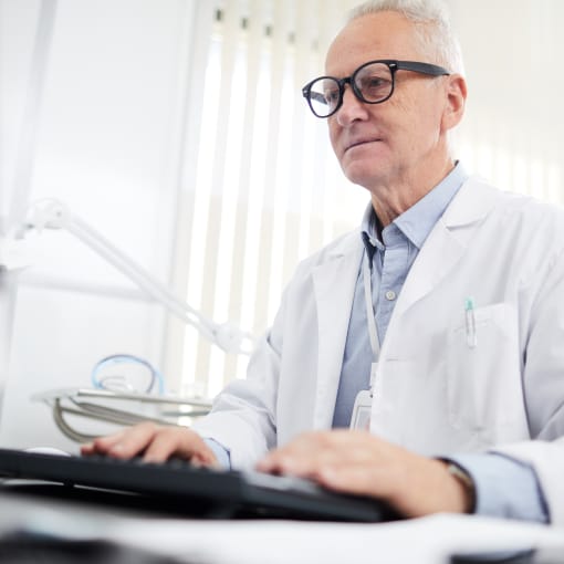 Doctor working on computer with medical records