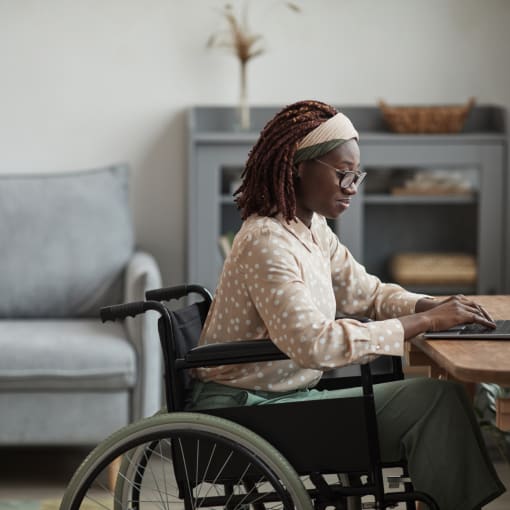 girl in wheelchair using laptop