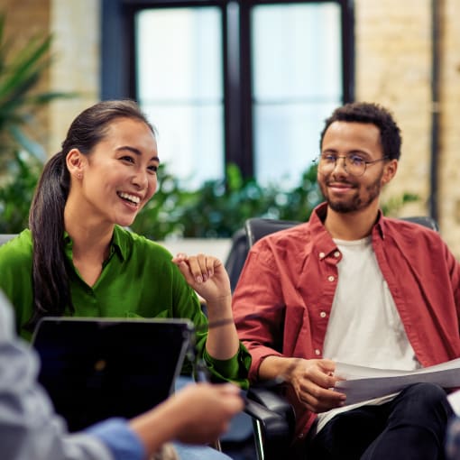 Four smiling office coworkers talking