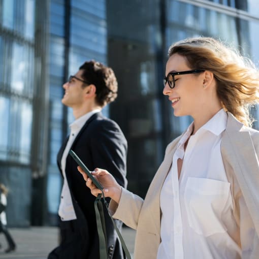 Female professional walking outside looking at mobile phone