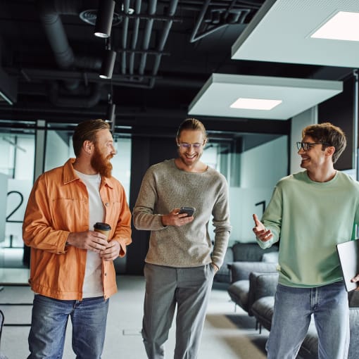 Three male colleagues talking and walking