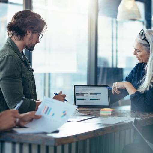 woman and man in office looking at laptop