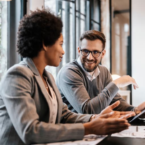 smiling man and woman in office discuss work