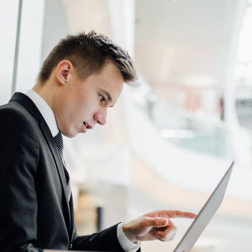 Businessperson points at the screen of a laptop.